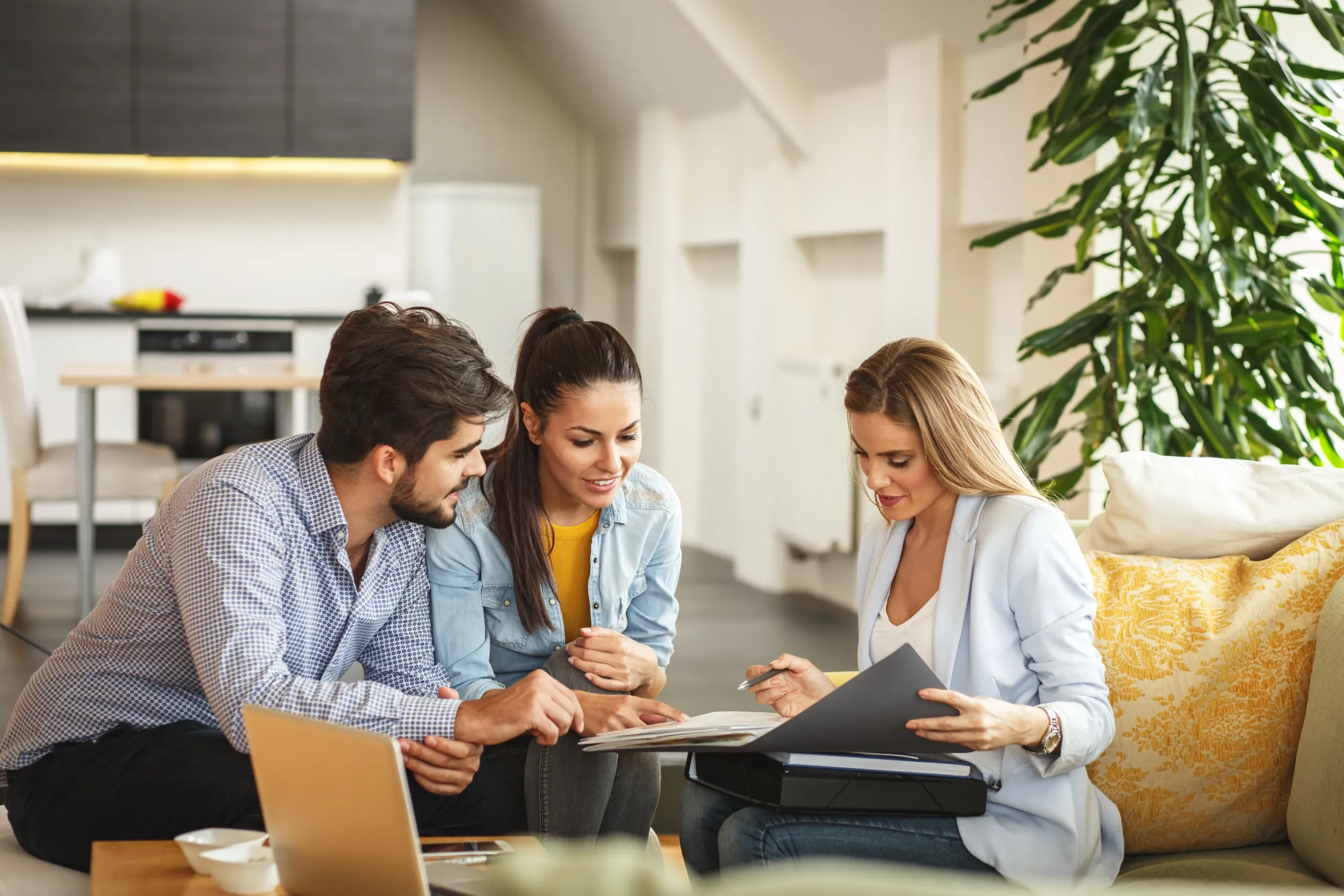 Recovery consultation with a couple reviewing paperwork alongside a professional for personalized treatment and care options.