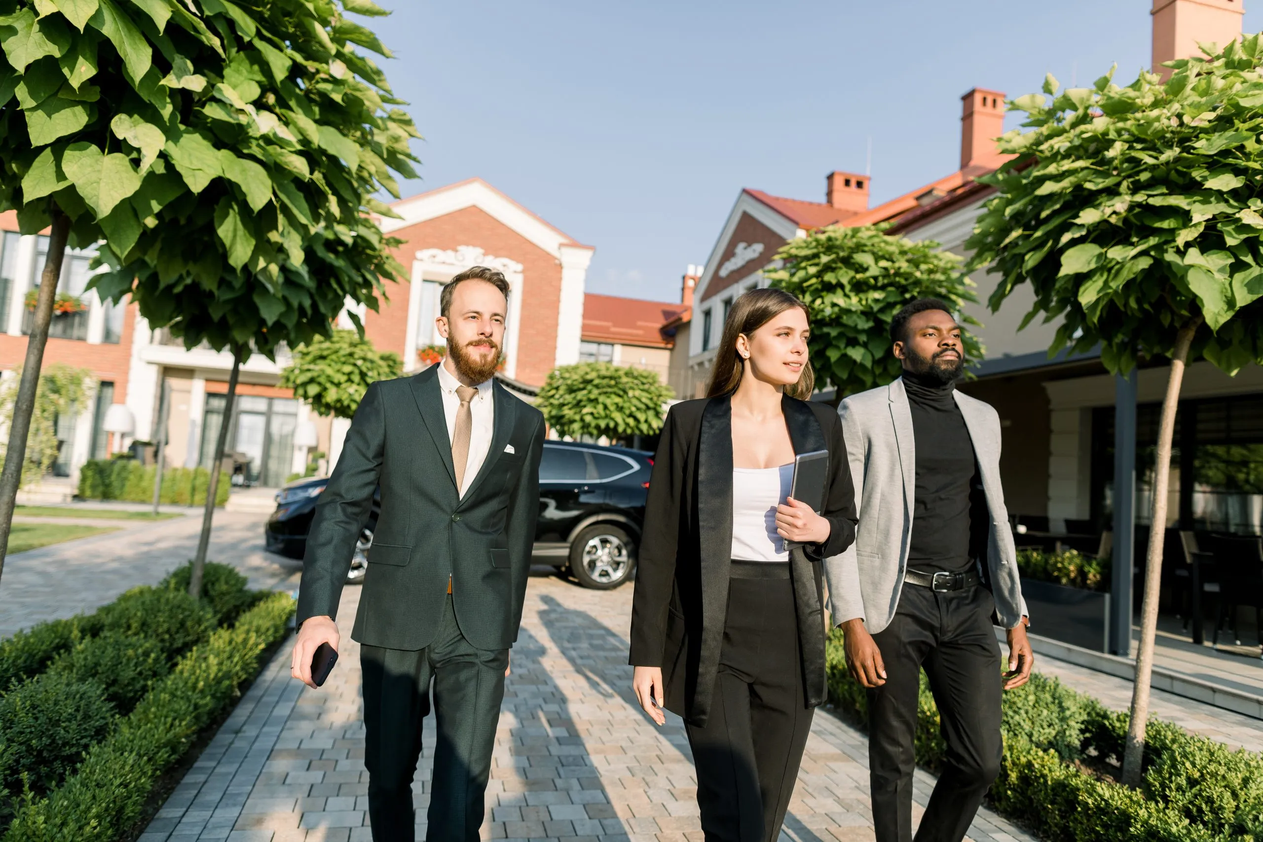 Business professionals walking outdoors in a residential community, representing trusted recovery support services.