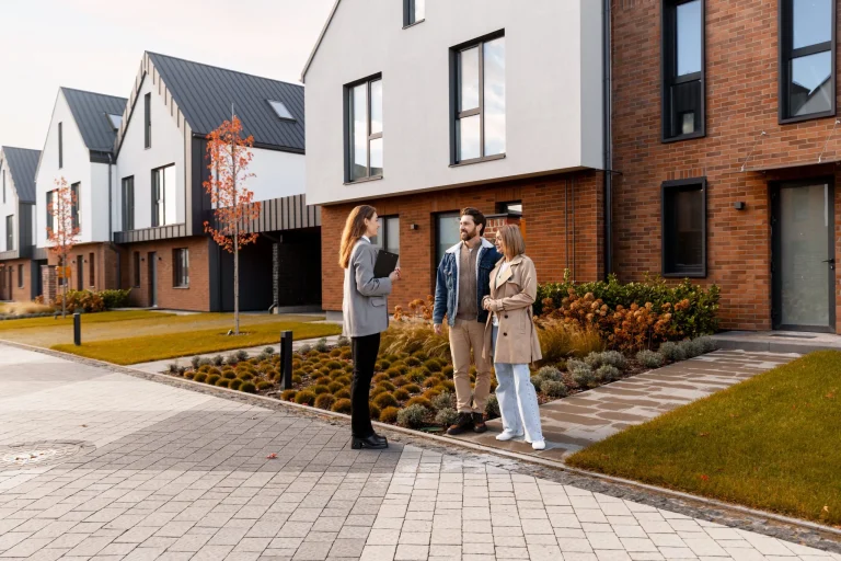 Real estate agent showing modern townhouses to clients, reflecting guidance given during property fund claims.