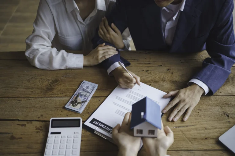 Young married couple speaking with a real estate agent, similar to homeowners consulting a surplus fund recovery specialist.